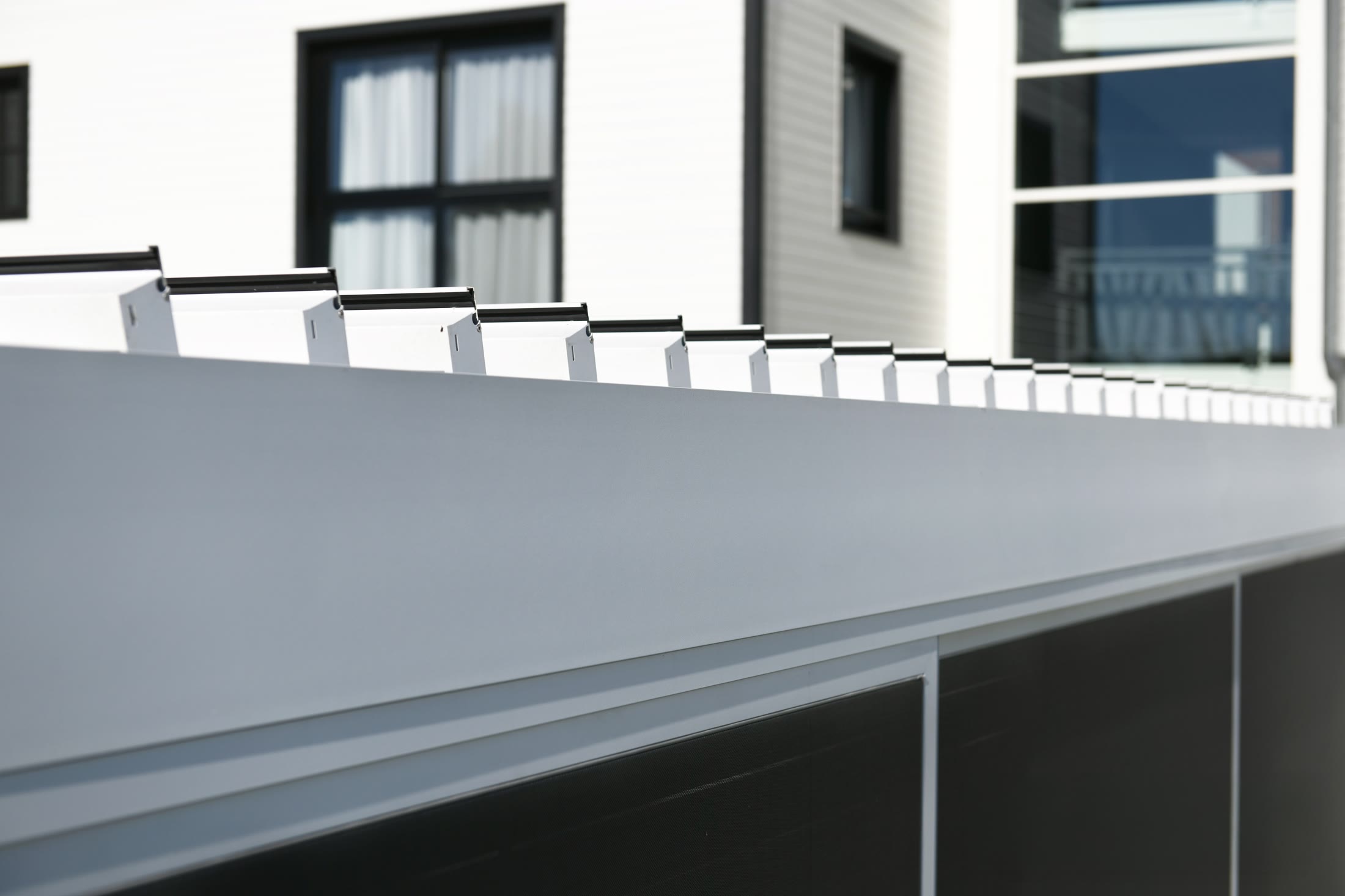 Close-up of Pergo Centro SO Climate motorized louver blades in a white pergola roof.