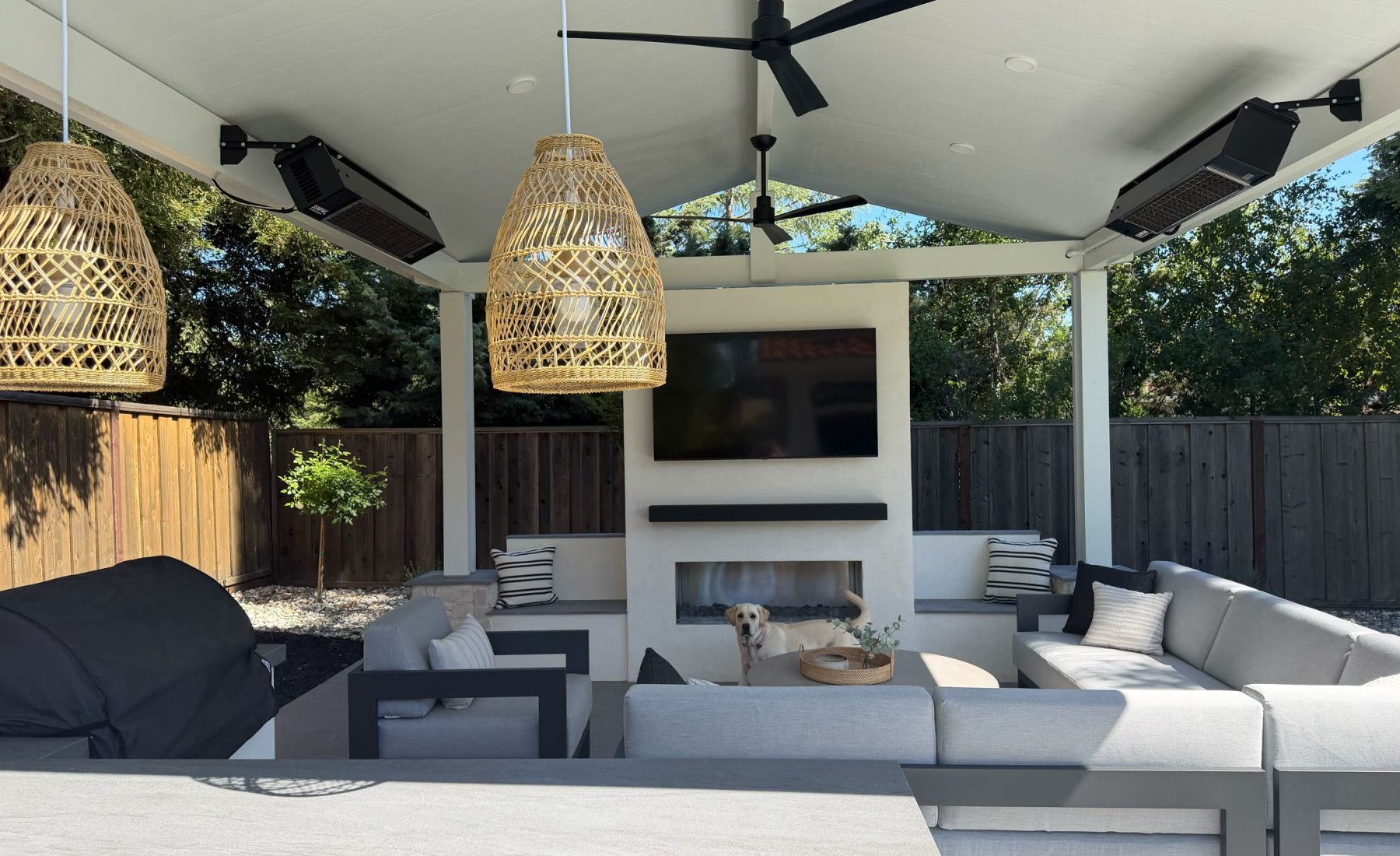 Furnished Danville covered patio with fireplace pendant lights heaters and seating.