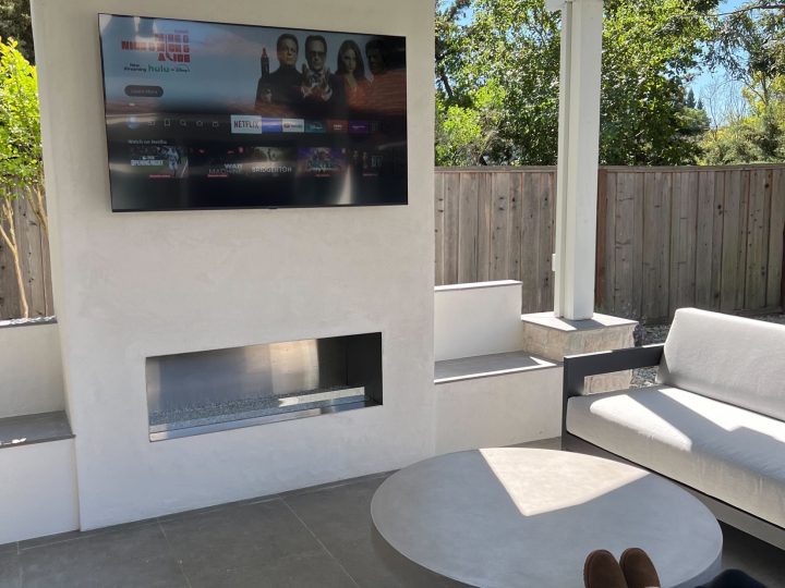 Custom Danville outdoor fireplace with mounted TV recess and firebox beneath the patio cover.
