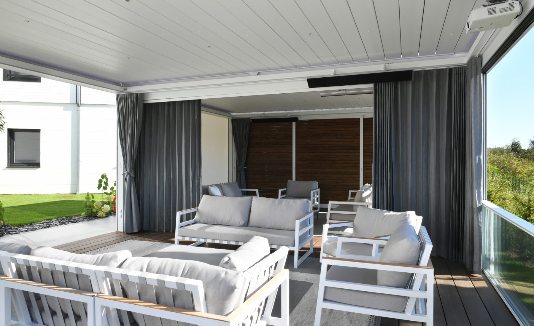 Pergo Centro SO Classic coupled patio cover divided by curtains over an outdoor lounge.
