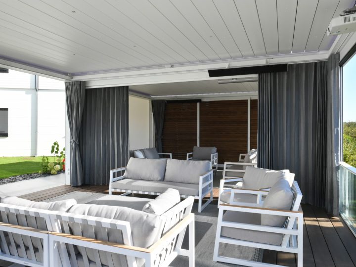 Pergo Centro SO Classic coupled patio cover divided by curtains over an outdoor lounge.
