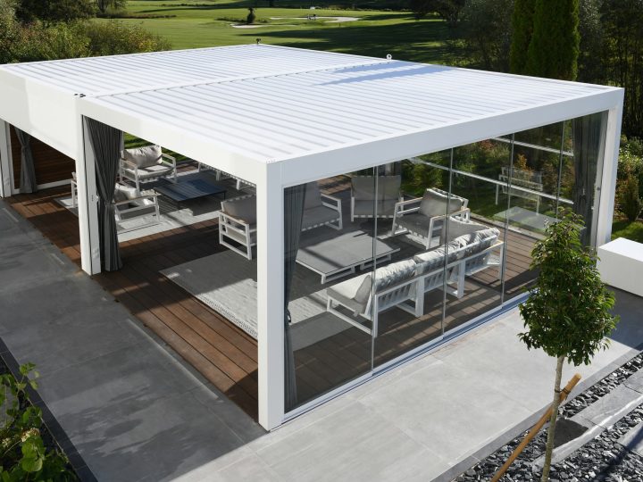 Pergo Centro SO Climate coupled louvered pergola with sliding glass walls and outdoor lounge seating.