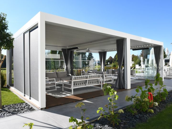 Pergo Centro SO Climate double pergola with curtains glass panels shade screens and lounge seating.
