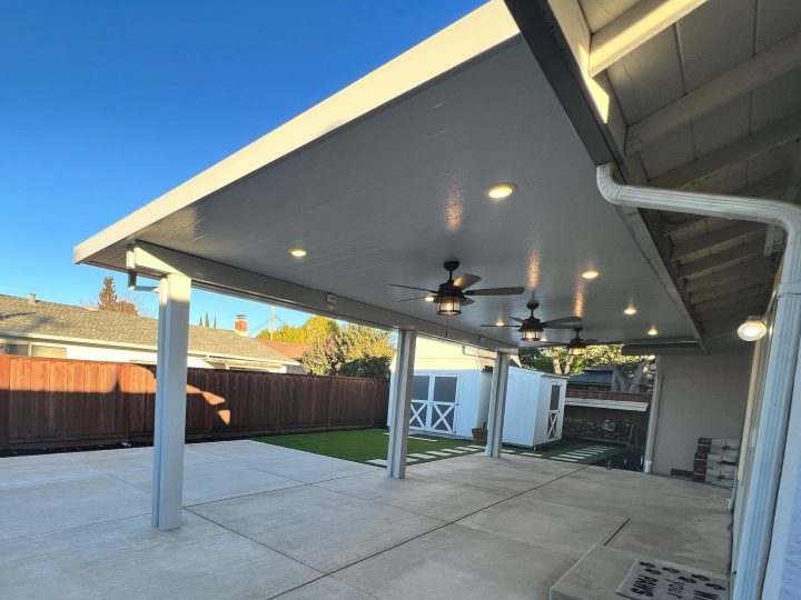 White patio cover ceiling with recessed lights and ceiling fans over a Livermore concrete patio by FG Pavers and Turf.